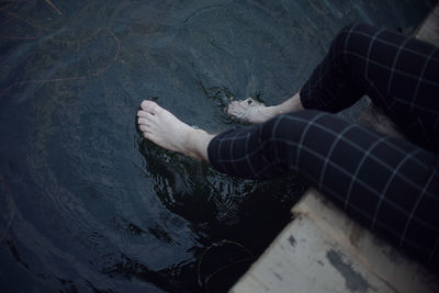 Low section of man standing by sea