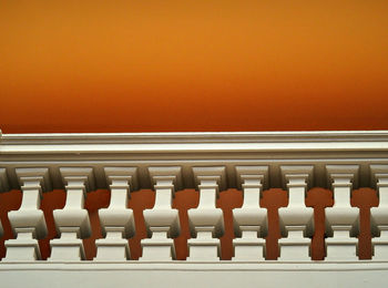 Low angle view of railing against orange background