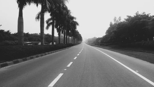 Road amidst trees against clear sky