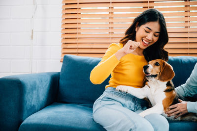 Portrait of young woman sitting on sofa at home