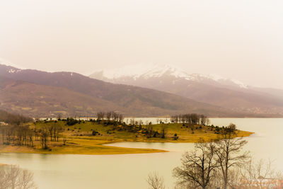 Scenic view of lake and mountains against sky