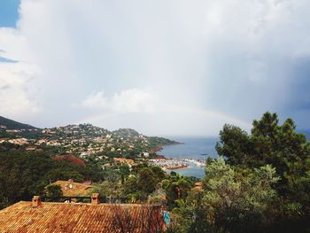 Scenic view of townscape by sea against sky