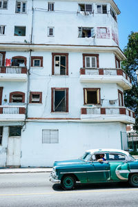 Cars on road by building in city