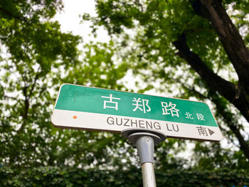 Low angle view of road sign against trees