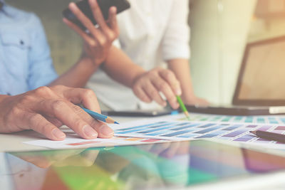 Close-up of people working on paper