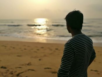 Rear view of man standing on beach