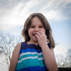 Portrait of happy girl against sky