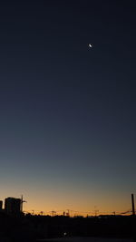 Silhouette buildings against clear sky at night