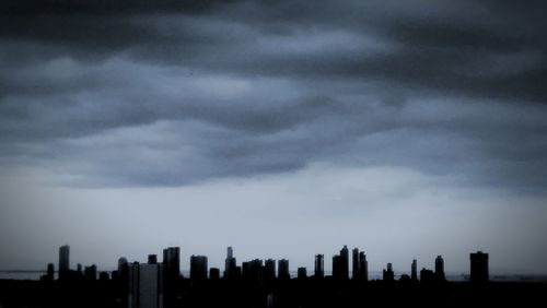 View of cityscape against cloudy sky