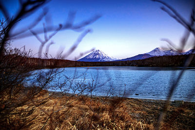 Scenic view of lake and mountains against blue sky