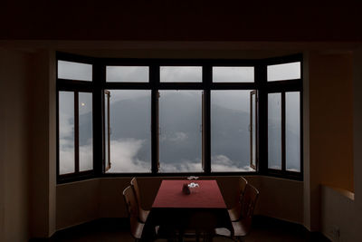 Empty chairs and table against window at home