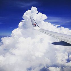 Low angle view of cropped airplane against sky