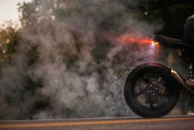 Cropped image of man riding motorcycle on road