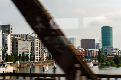 Bridge over river in city against sky