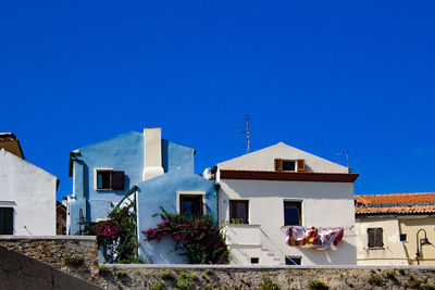 Low angle view of buildings against clear blue sky