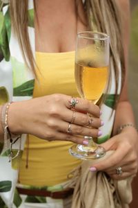 Midsection of woman holding drinking glass