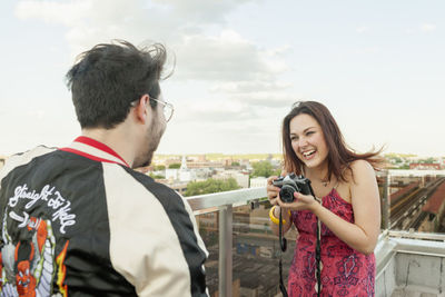 Young woman taking photographs of her friend