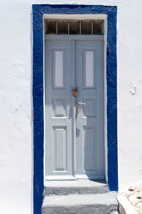 White and blue door in the old town of oia, santorini island, greece