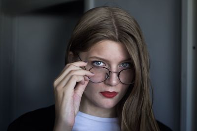 Portrait of young woman in eyeglasses at home