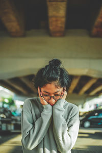 Woman standing under the bridge confused 