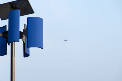 Low angle view of airplane against the sky with street light 