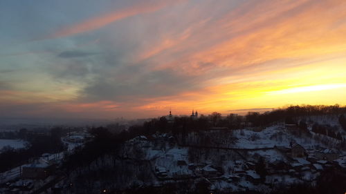 Scenic view of snow covered landscape at sunset