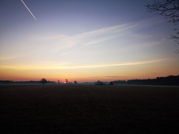 Scenic view of silhouette field against sky during sunset