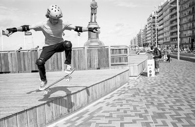 Full length of man skating in city against sky