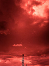 Low angle view of communications tower against dramatic sky