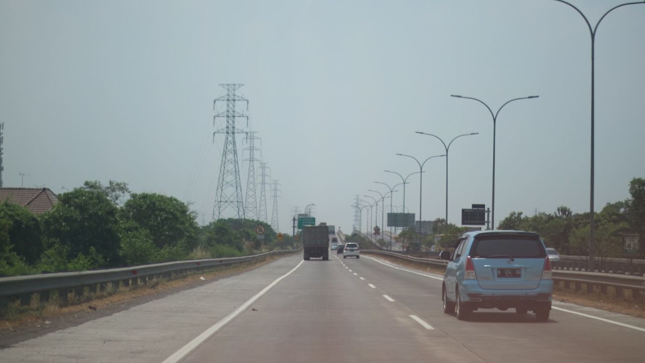 VEHICLES ON ROAD AGAINST SKY