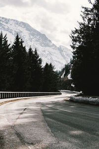 Road by trees against sky