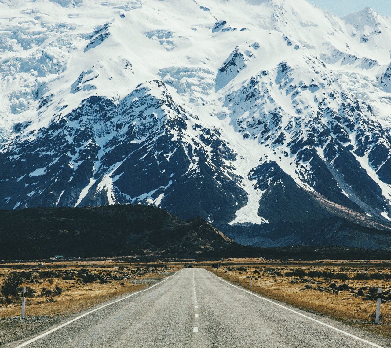 AERIAL VIEW OF ROAD ON SNOWCAPPED MOUNTAINS