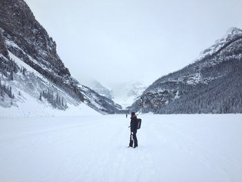 Young man skiing against on snowcapped mountains