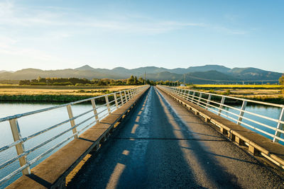 Road leading towards mountains against sky