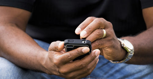 Close-up midsection of man using mobile phone