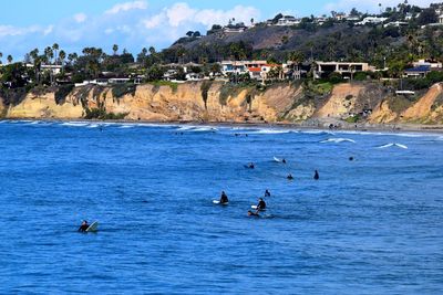 People enjoying in sea against sky