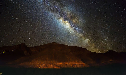 Scenic view of mountains against sky at night