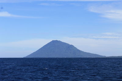 Scenic view of sea and mountains against sky