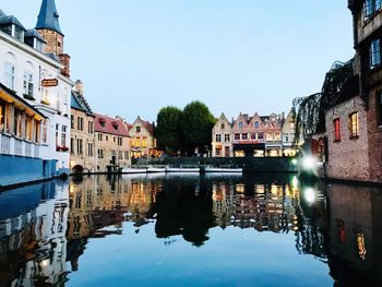 Canal amidst buildings against clear sky