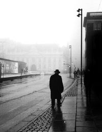 Rear view of man walking on street in city