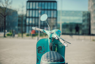 Rear view of old scooter in front of office building
