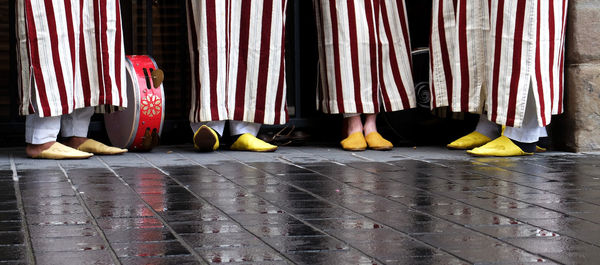 Low section of musicians standing by wet street