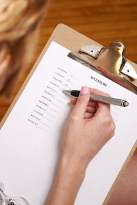 High angle view of woman writing on paper