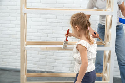 Side view of a boy standing against wall