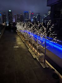 High angle view of illuminated street amidst buildings at night