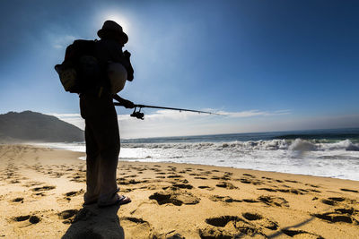 Man standing on beach against sky