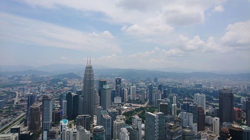 View of cityscape against cloudy sky