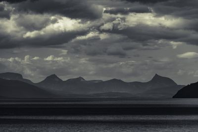 Scenic view of sea and mountains against sky