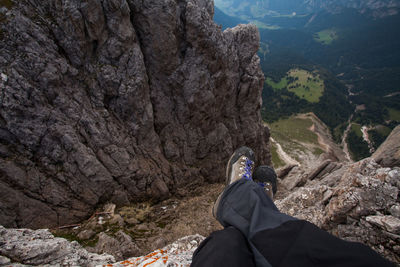 Low section of man sitting on rocks