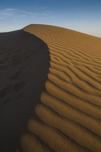 Sand dunes in desert against sky